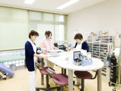 室内で入居者の健康管理について相談する、看護師と介護スタッフ