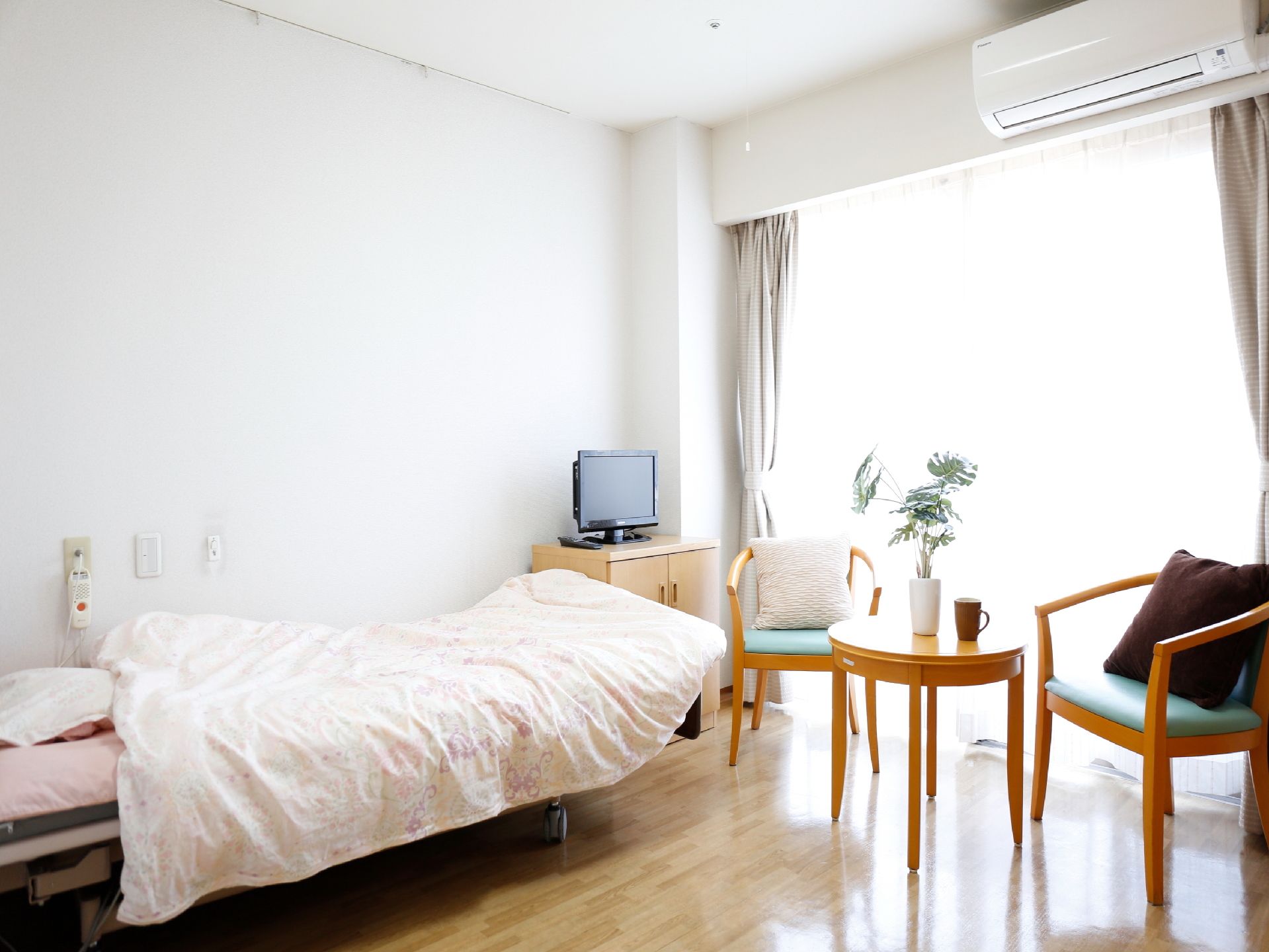 緊急の時に職員を呼び出すことができるブザーがベッドヘッドそばの壁面に設置してある。電動ベッドがある。