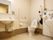 壁面が白でバリアフリーの床で、大面鏡がついた洗面台、オスメイト対応トイレとなっている。手すりが壁に設置してある。