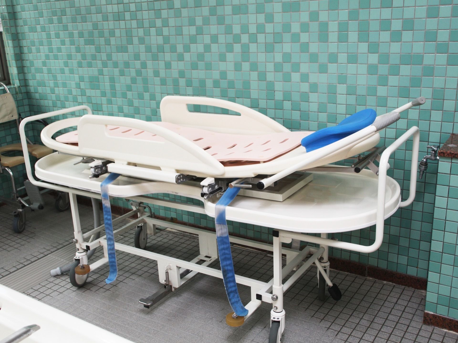 お風呂で用いるストレッチャーなどの器具も用意されている。お湯が流れていくように穴が開いた滑り止めがついている。