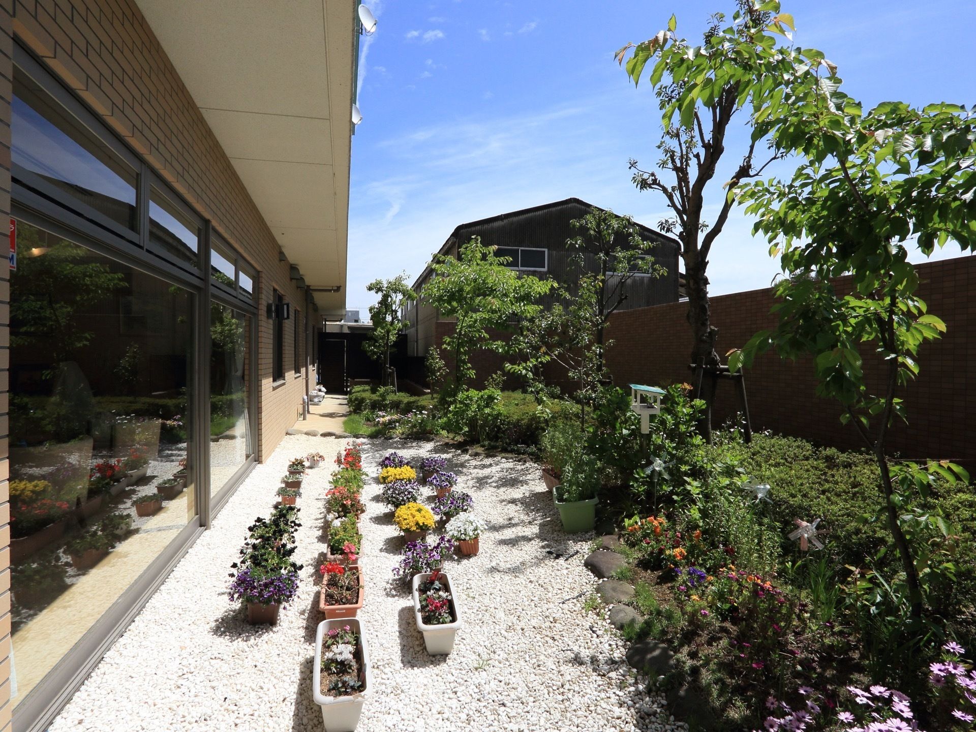 １階には石が敷かれた庭がある。プランターの花や木が植えられていて、緑を感じながら穏やかに生活することができる。