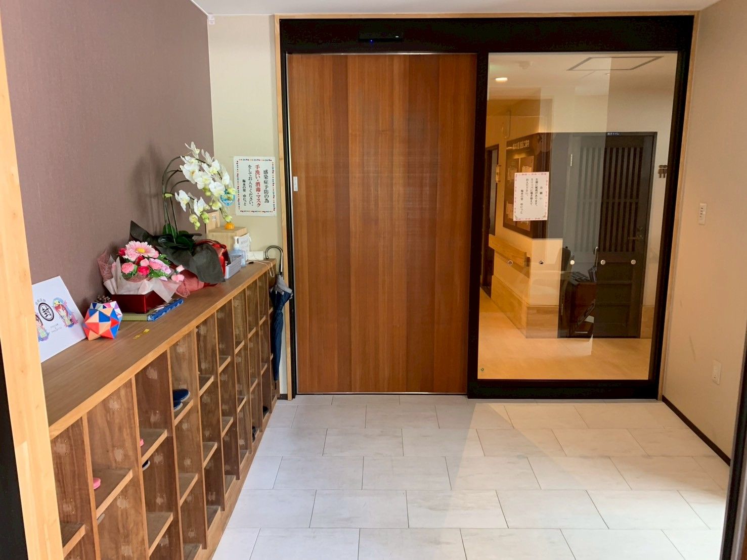 木製の靴箱と扉のある玄関