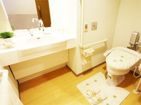 洗面台が併設されているトイレ。手すりがついており、入居者様が楽に使用できる。便座は温水洗浄機能付きである。