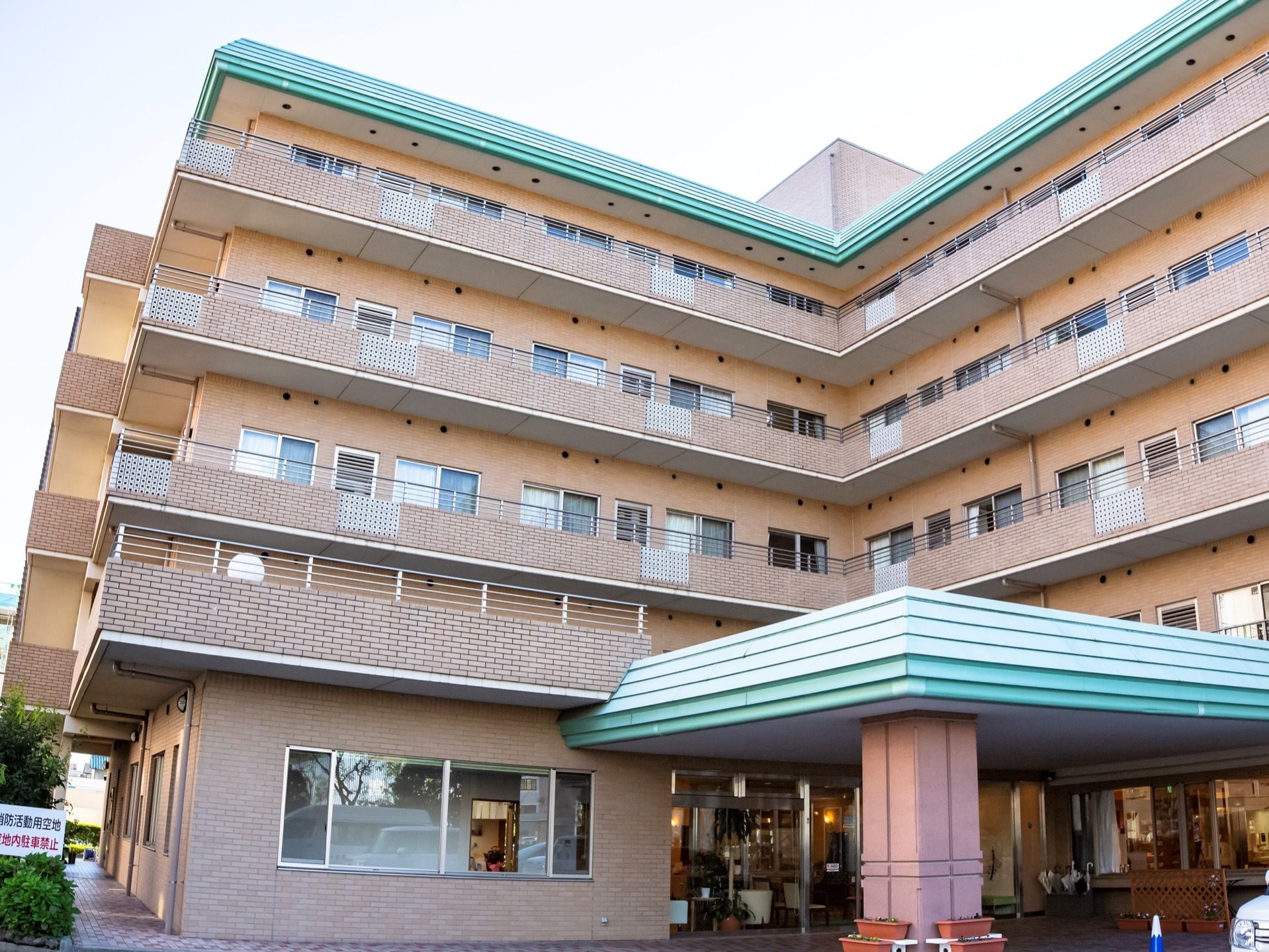 ベージュのレンガ調の外壁とグリーンの屋根が特徴的である。５階建てのマンションタイプで、24時間365日、介護サポートがついている。