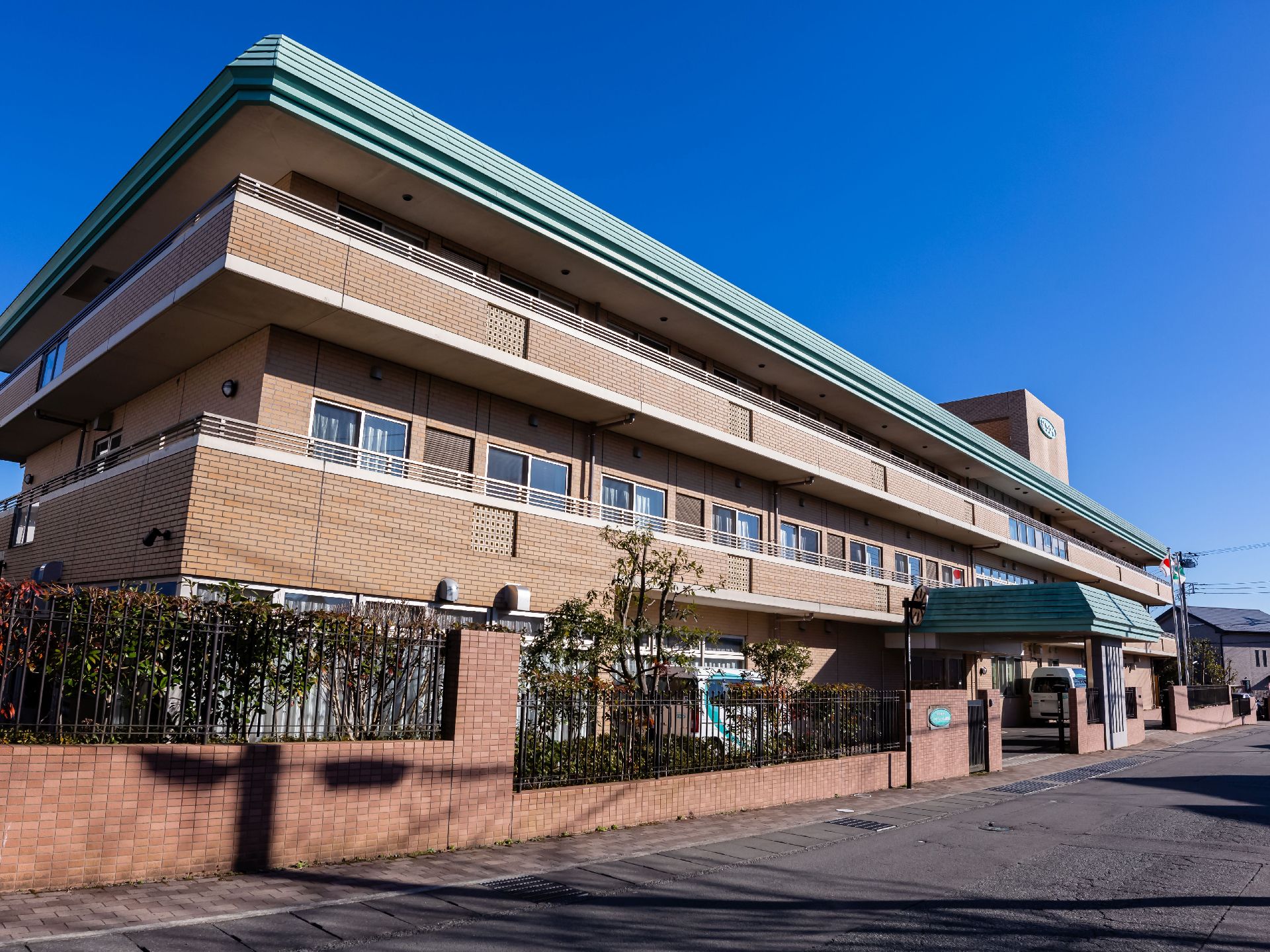 三階建てのレンガ造りの大きな建物がある。周囲は同じレンガ素材で作られた壁と柵に囲われており、樹木が植えられている。
