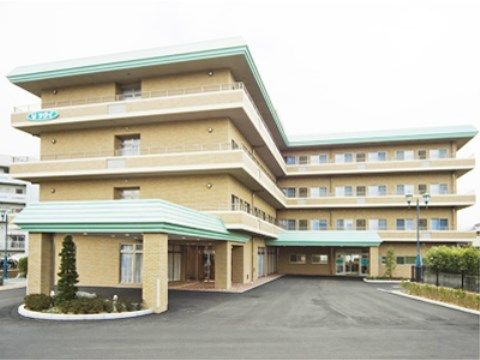玄関アプローチがある、L字型構造で4階建ての施設外観