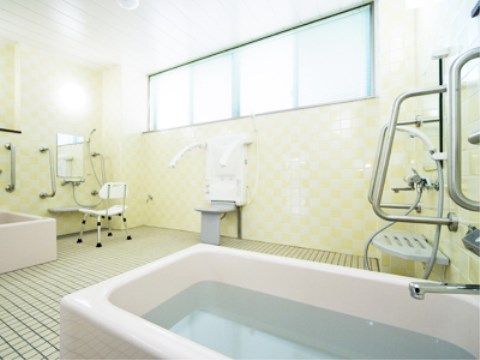 白いシンプルなバスタブが複数置かれている浴室である。鏡付きの洗い場で、床は白のタイル張りとなっている。