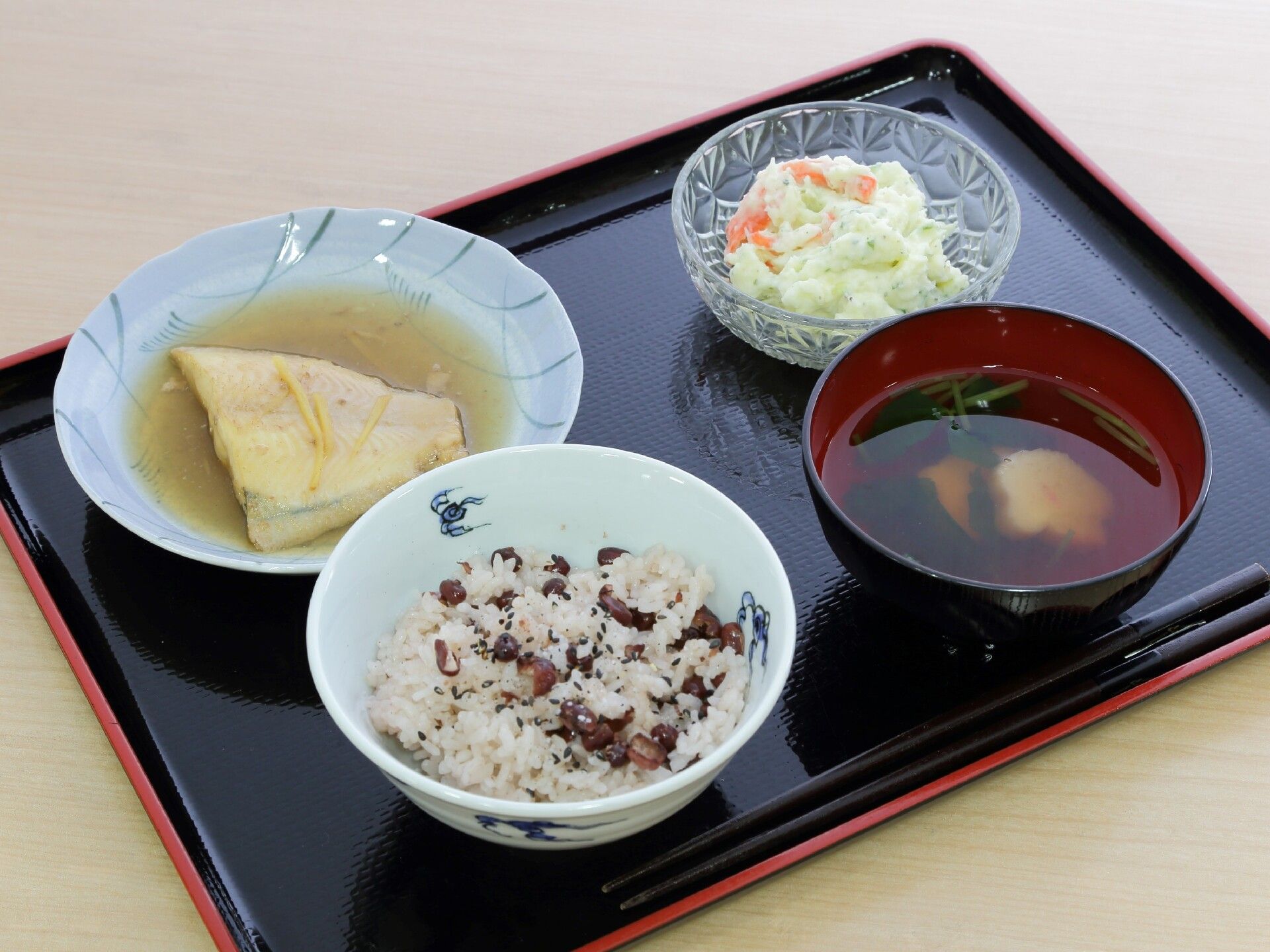 汁物と豆ごはんの和食のセット。魚の煮つけとサラダが付いている。