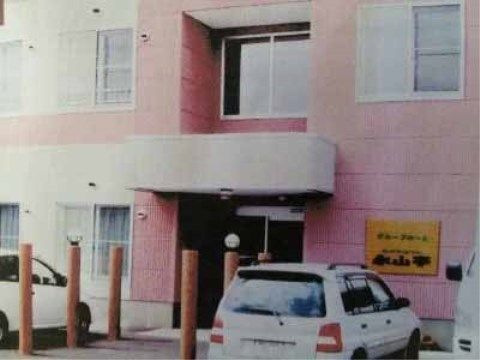 ピンクの外壁の建物エントランス