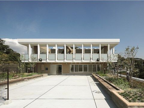 おしゃれな外観をした建物周辺には花壇があり、木々が植えられている。玄関には段差がないので出入りが楽に行える。