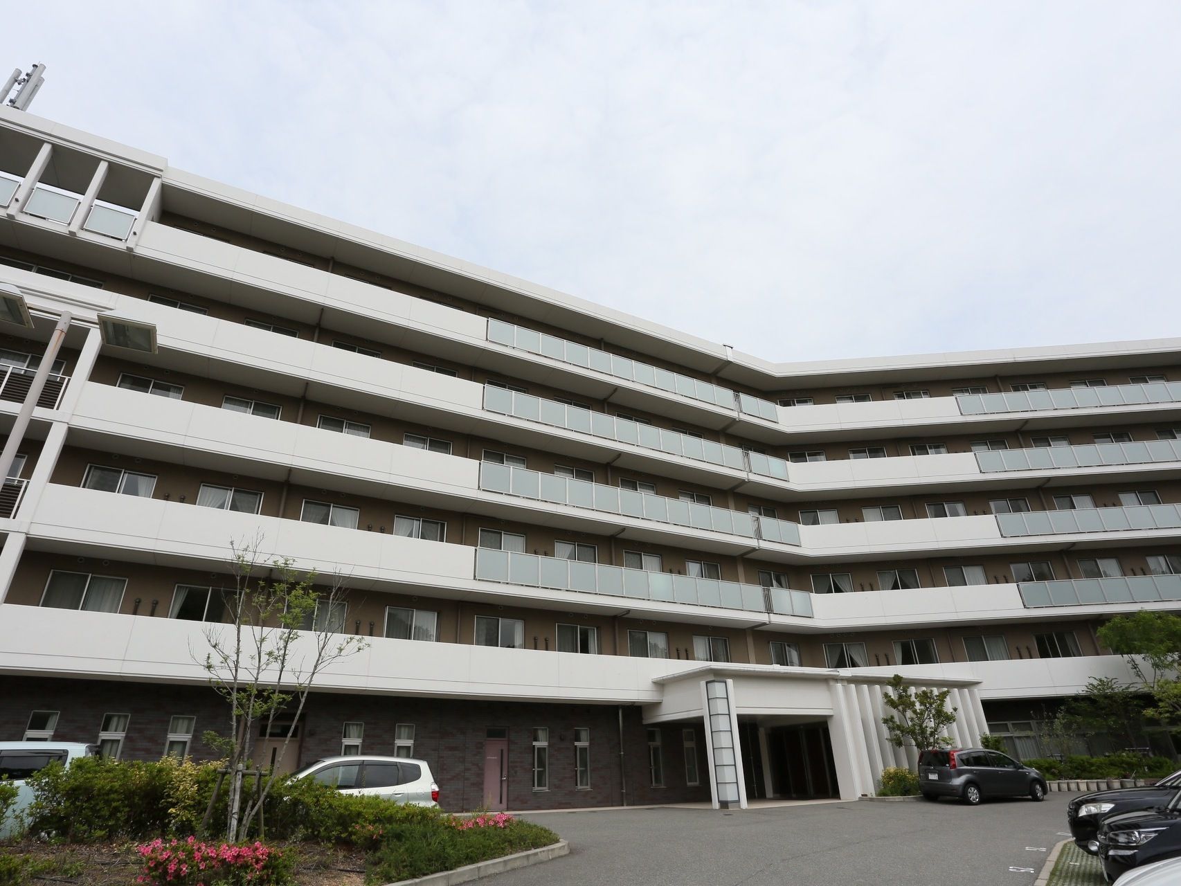 敷地が広く開放感がある。建物は6階建てで横に広い。ロータリーには草木が植えられていて明るい印象を受ける。