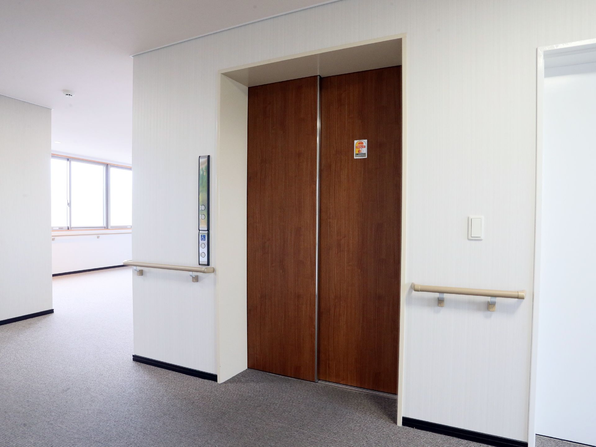 エレベーターから出るとすぐに手すりが設置されている。それぞれ壁は白色、天井は白色、床は灰色となっている。