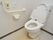 トイレルームの真ん中に便座が置かれてあり、壁際にはトイレットペーパーの他、手すり、そして黄色のシールに黒でSOSと書かれた呼び鈴がある。