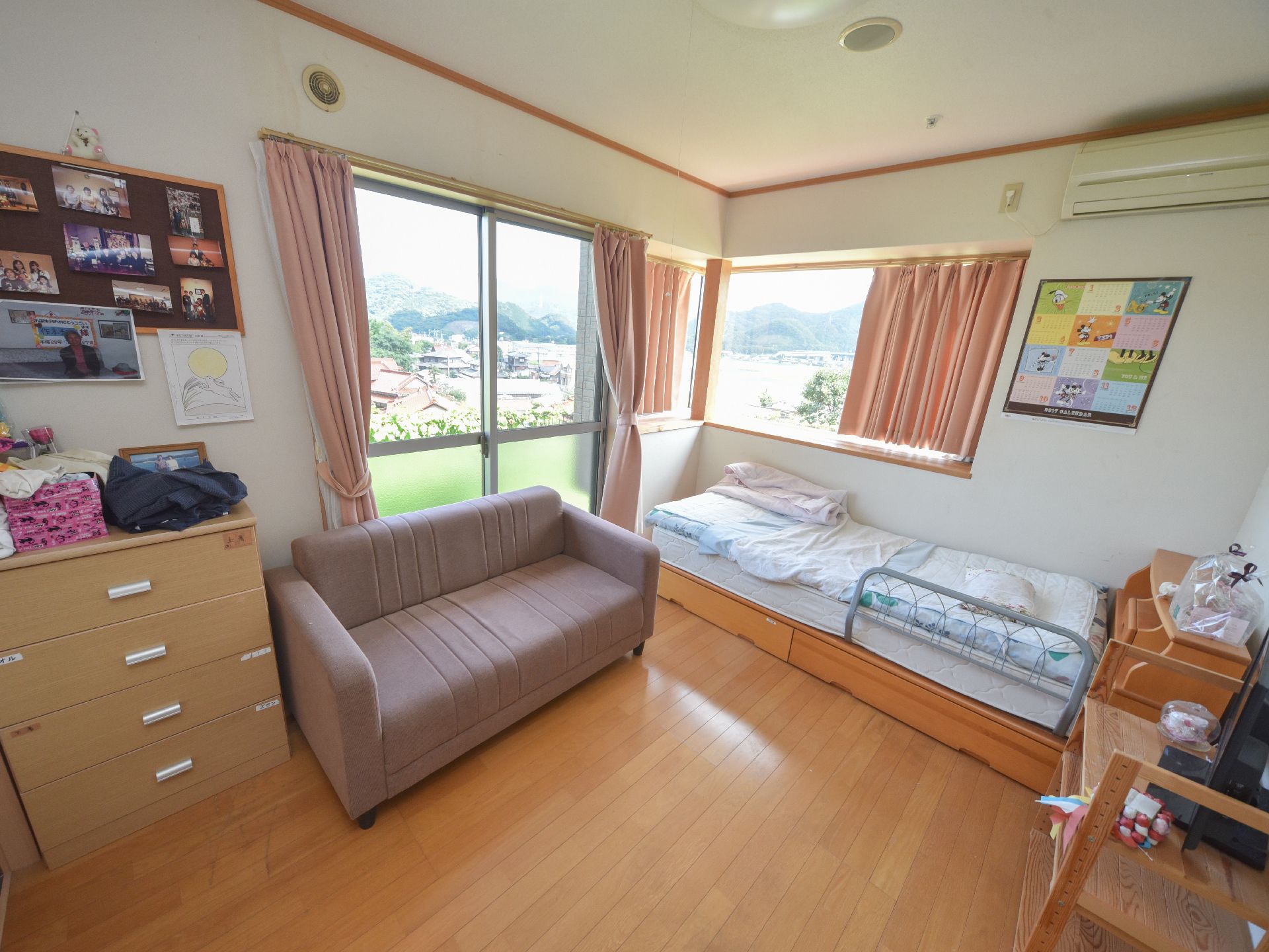 個室の窓には外の景色が広がっており、奥には山も見えて絶景となっている。個室内には壁際に様々な写真が貼られている。
