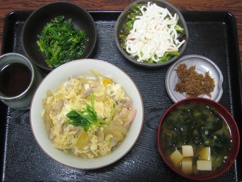 野菜がふんだんに使われ、バランスの考えられた食事。親子丼と味噌汁、青菜の胡麻和え、サラダ、佃煮などが並んでいる。