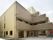 ベージュをベースにした柔らかな色合いの三階建ての建物である。玄関先には手すりやスロープを設置している。