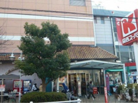 施設の近所にある柔らかい色合いの壁と赤い看板が目印のスーパーマーケットである。周辺地域の人々が利用している。