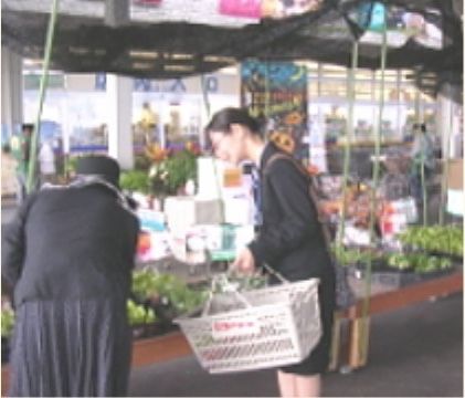 店頭で商品を選ぶ入居者様と、その買い物に店舗まで付き添いをするスタッフ