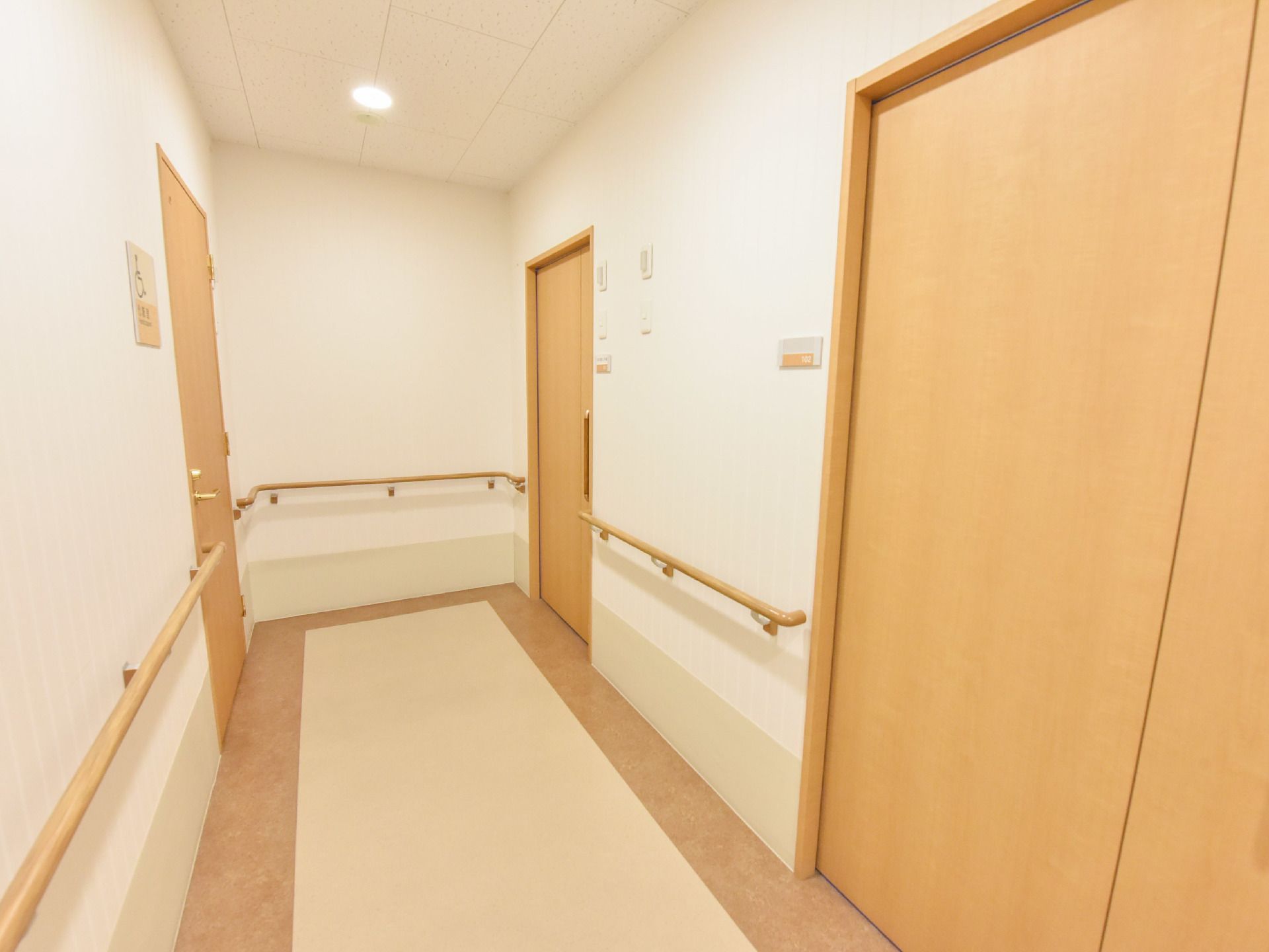 廊下は基本的に白い壁をしている。居室の他様々なドア、そして張り巡らされた手すりは木製。床のデザインも特徴的なものになっている。