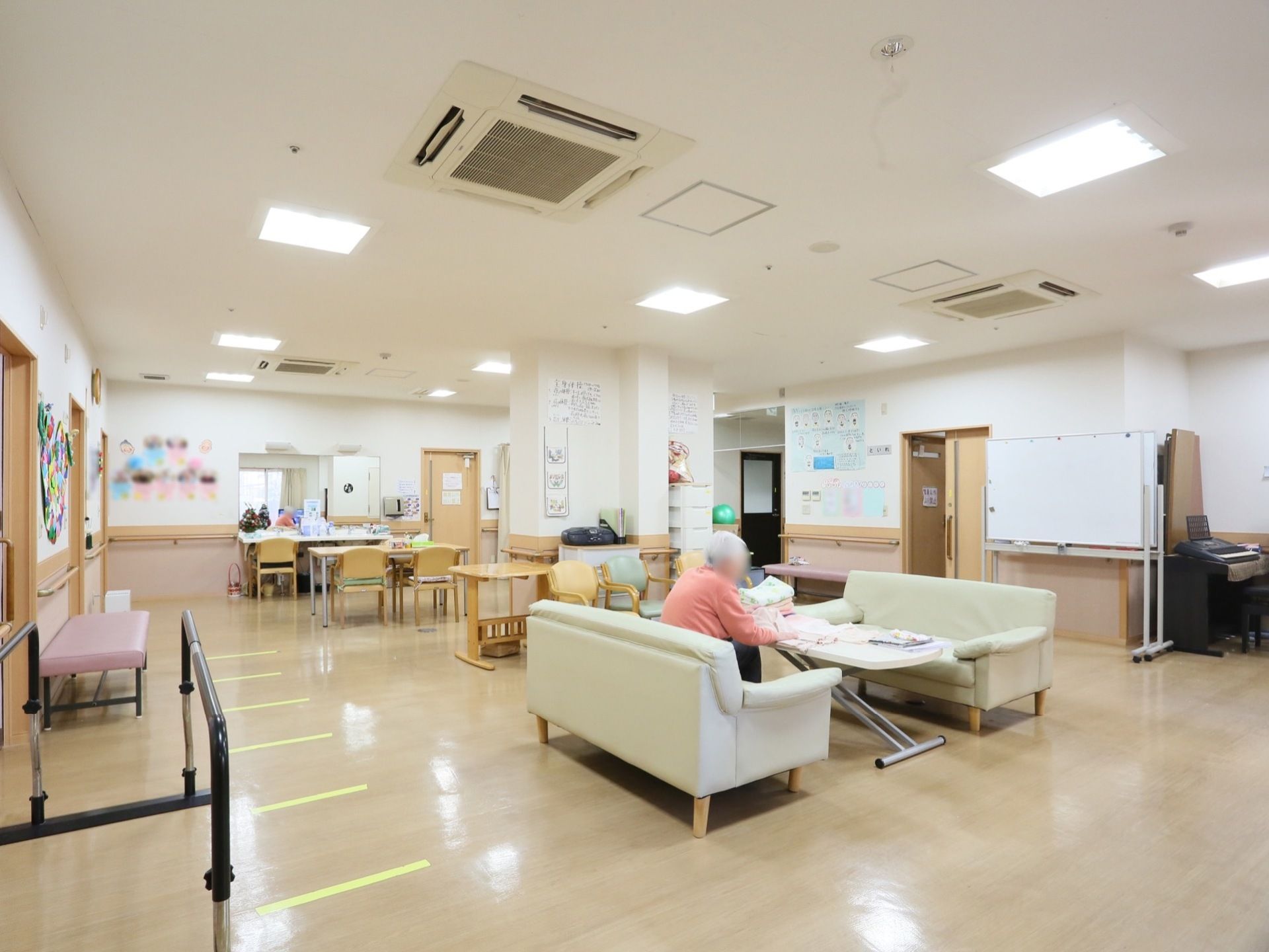 広い共有スペースで、椅子やテーブル、大きいソファが設置されている。入居者様はのびのびと過ごすことができる。