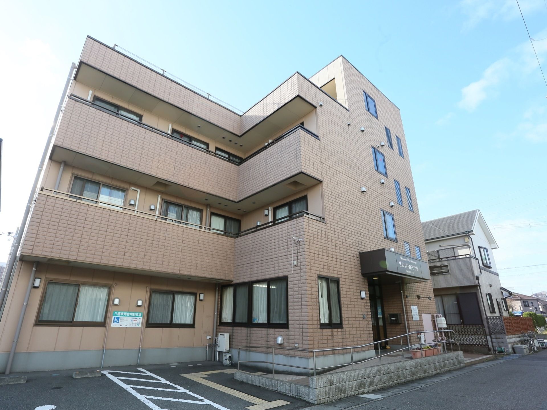 三階建ての施設で、アットホームな雰囲気がある。入口のすぐ近くに駐車場があり、来訪しやすくなっている。