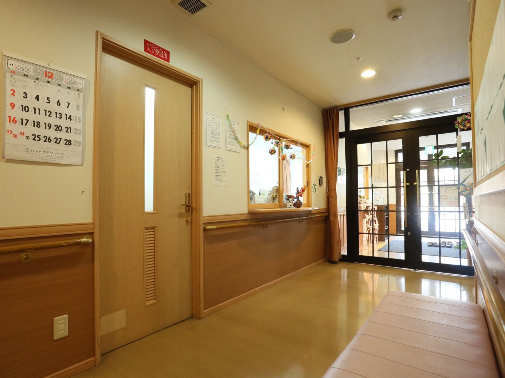玄関は二重扉になっており、扉の側には受付の窓と入口がある。廊下の壁には手すりやソファが設置されている。