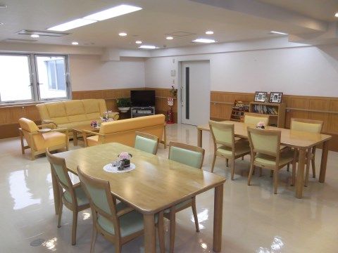 ダイニングスペースには木目調のテーブルセットが置かれていて、リビングスペースにはイエローのソファーセットが設置されている。