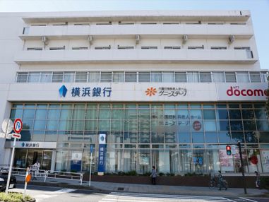 施設の外観は、他の企業と隣り合った形となっている。複数階建ての建物となっており、地上の道路部分に人が歩いている。