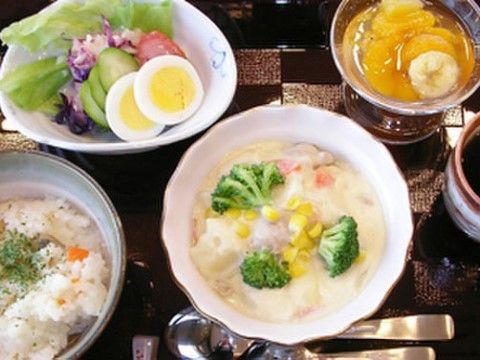 ホワイトシチュー、グリーンサラダなど３種類のおかずにデザートのフルーツゼリーを添えた食事