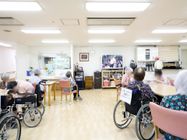 壁の前には大型テレビがあり、その横には大きな鏡の付いた洗面台が2つ並んで設置されている。棚の上には複数のポットが置かれている。