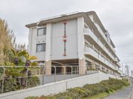 グループホームの施設は、４階建ての建物になっている。周辺にビルなどはなく、見晴らしの良い高台に位置している。
