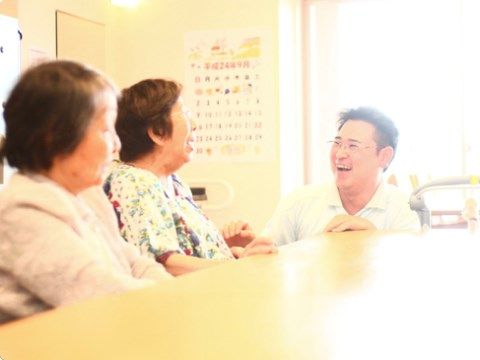 リビングで高齢者を介護する介護スタッフの様子