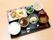 黒のトレーにご飯、汁物、メインのおかずに3つの小鉢が置かれている。栄養バランスを考慮されたメニューになっている。