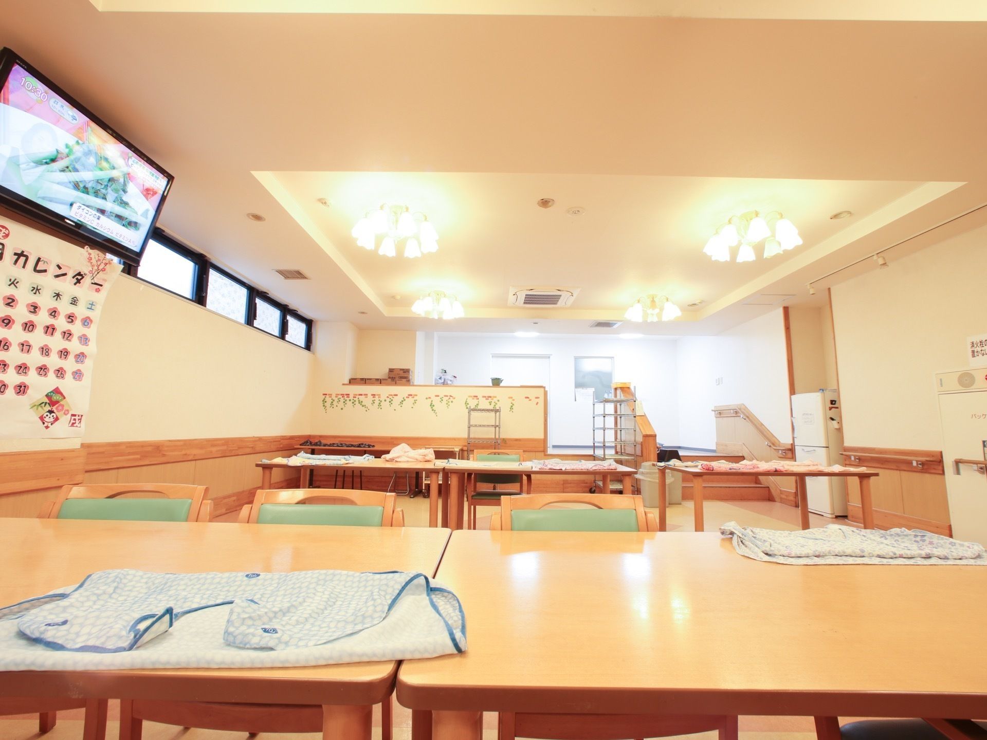 清潔感があり、天井の照明が暖かい色合いで明るい印象の食堂