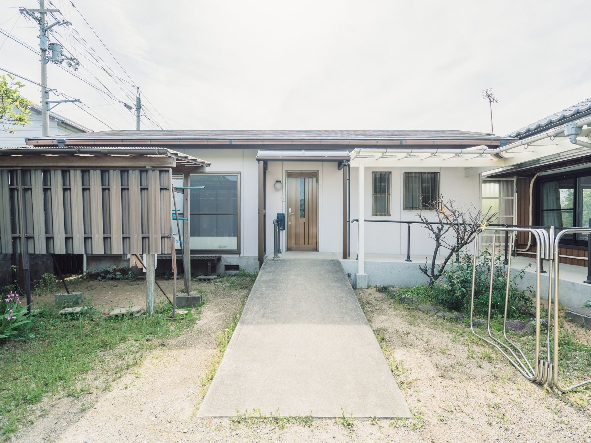 木造平屋建てで、玄関前にはスロープが設置してある。洗濯干しや布団干しスペースが確保してある。小さな花壇もある。