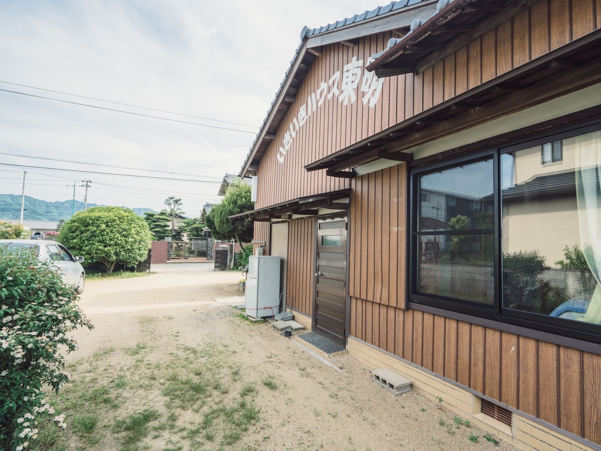 木材のぬくもりが感じられる、落ち着いた色合いの建物である。屋根下には白い文字で、施設の名前が書かれてある。