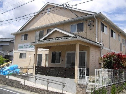 ２階建てで三角屋根の下に時計が取り付けられている施設外観