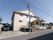 木造２階建ての建物の周囲には駐車スペースがある。建物の壁には、緑色で書かれた施設名の看板が取り付けられている。