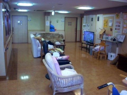 大型テレビに向けてソファや１人用の椅子が置かれている広間