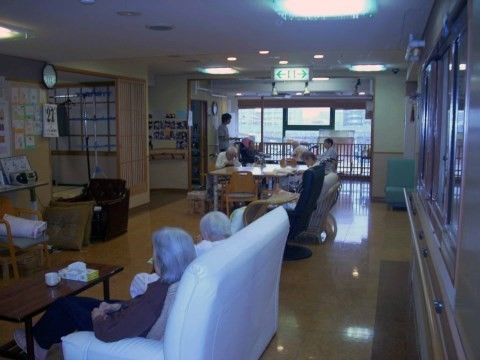 ソファやテーブルセットでたくさんの入居者様がくつろいでいる共用部