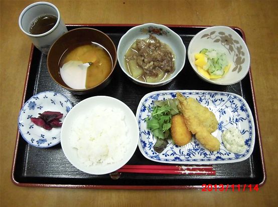 タルタルソースを添えたミックスフライとご飯と味噌汁が付いたメニュー