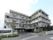 白を基調とした四階建ての建物である。駐車場も完備しており、ご家族の来訪にも便利。快適な生活を送れる環境が整っている。
