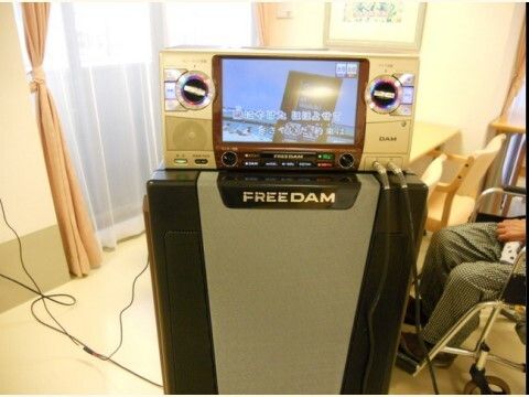 仮装したスタッフと席に着きイベントを楽しむ高齢者