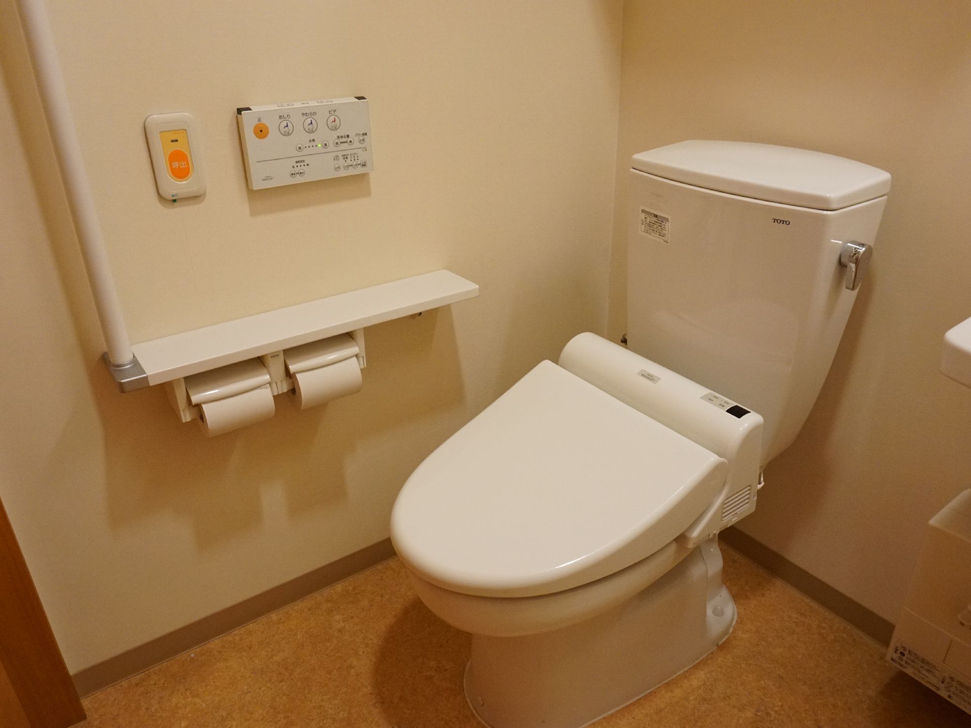 バリアフリー完備で、壁に手すりが設置されてているトイレ