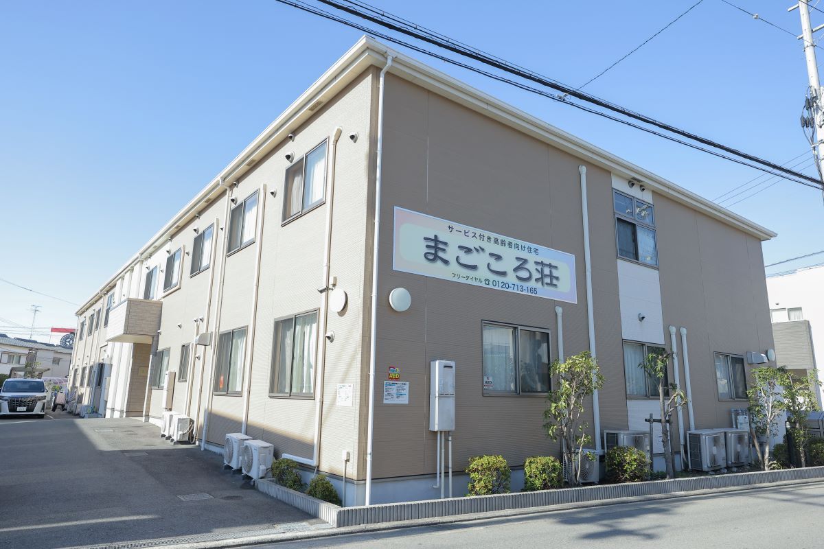 芝生が植えられた広場の前に建っている、２階建ての建物