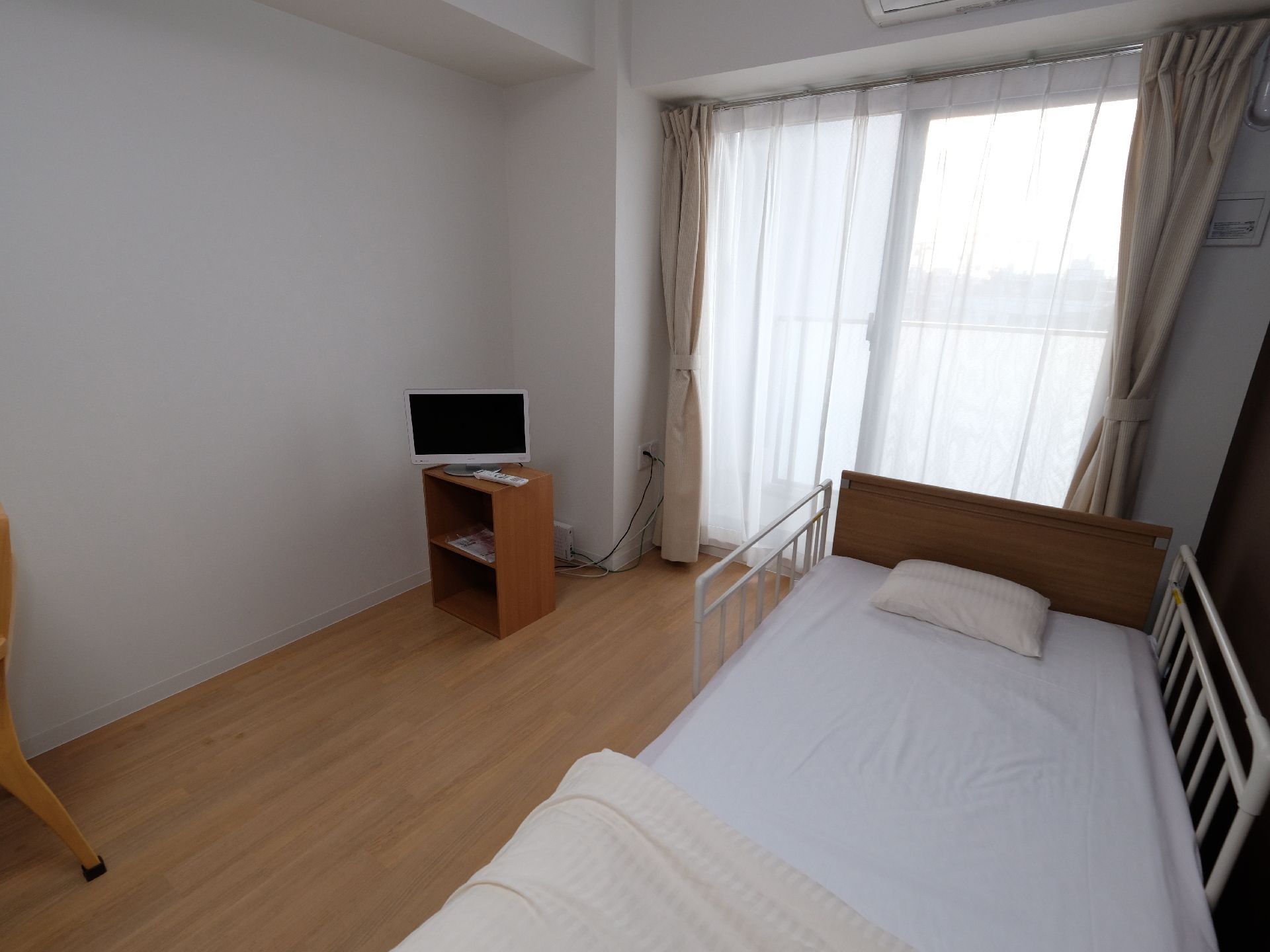 介護居室では、介護ベッドにも内装と色調のマッチしたものを使用。居住者があ落ち着いた気持ちで毎日を過ごしていただくための配慮。