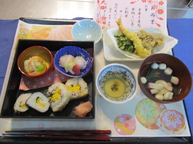 お品書きの付いた天ぷらの盛り合わせと太巻き寿司のセット
