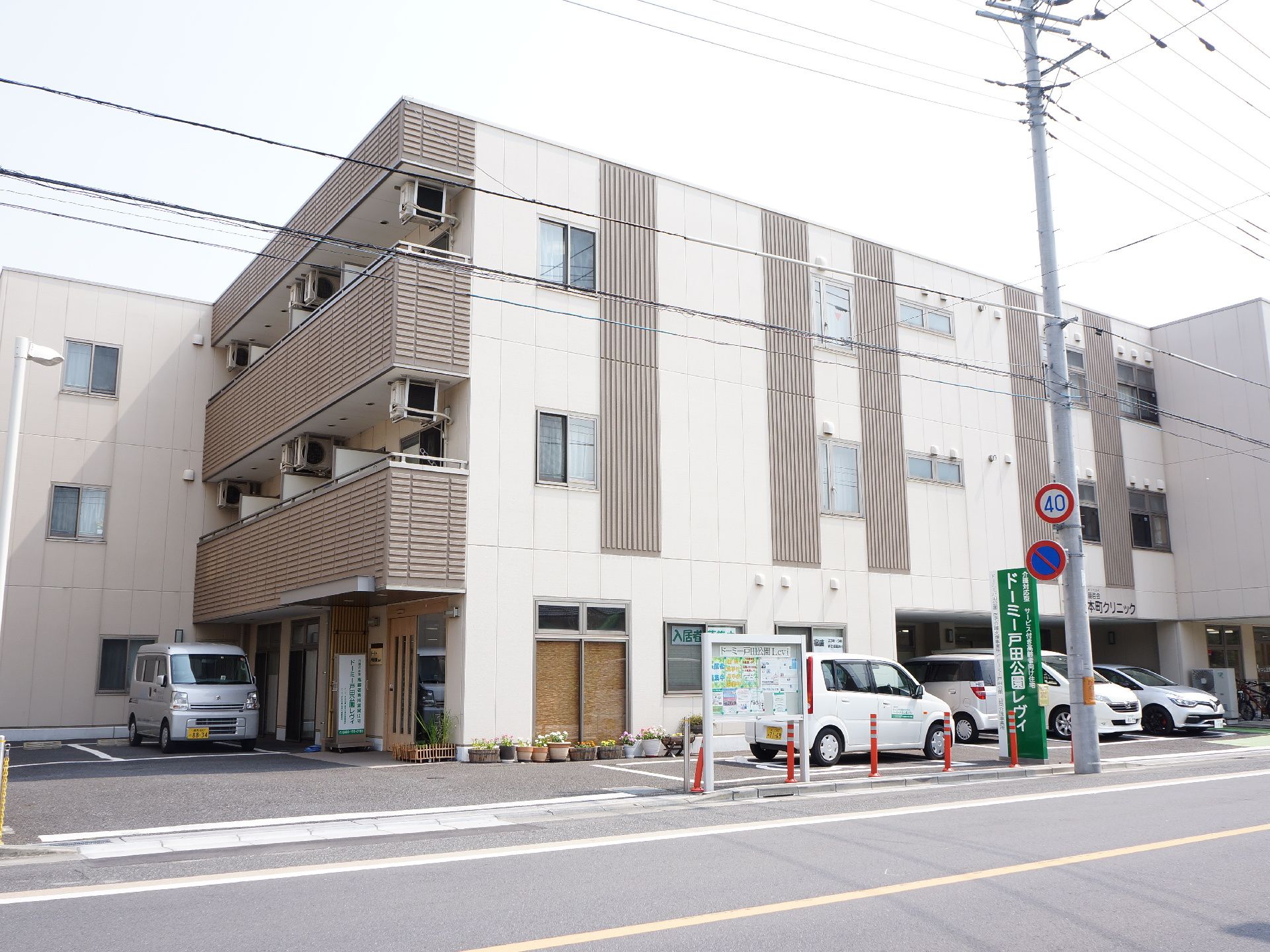 入口の近くに駐車場がある。3階建ての大きな建物で、広い。ベランダもあり、オシャレな外観となっている。