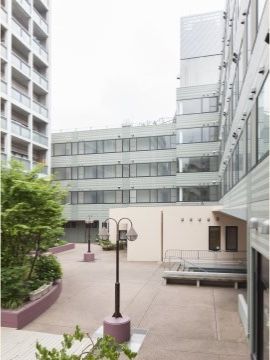 周囲を４階建ての白い建物に囲まれている、舗装された中庭