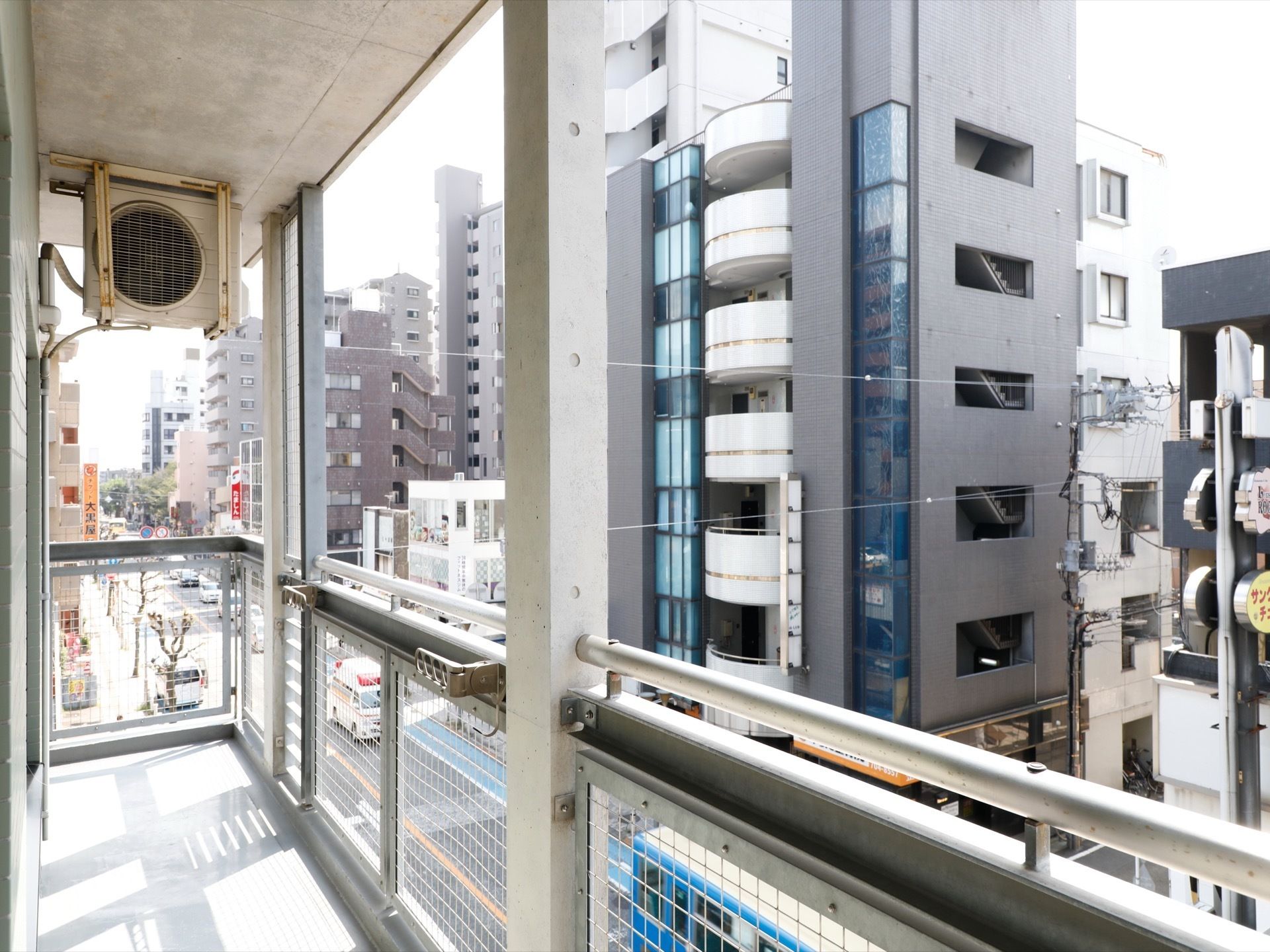 中央近辺には柵があり、格子状になっている。右側には道路が通っている。周辺はマンションが立ち並んでいる。